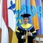 Andi Teguh di depan bendera-bendera dalam gedung UTCC setelah Wisuda