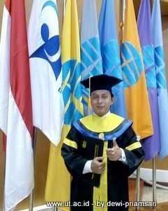 Andi Teguh di depan bendera-bendera dalam gedung UTCC setelah Wisuda